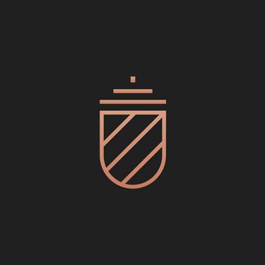 Ein einfaches, stilisiertes Wappen in Kupferfarbe mit diagonalen Streifen und einer oberen Kappe auf einem dunklen Hintergrund.