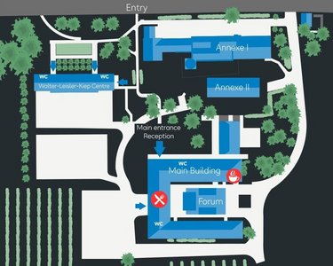 Site plan of an area featuring various buildings, including the main building, reception, and forum, surrounded by green spaces and vineyards. Entrances are marked, and a route is outlined.