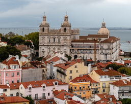 View of the old town with colorful houses and the impressive architecture of a church by the water.