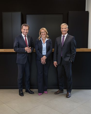 Frau Dr. Dorothée Hofer, Geschäftsführerin der EBS Universität, Günther H. Oettinger, Präsident der EBS Universität, und Prof. Dr. Henning Werner, Rektor der EBS Universität, stehen vor dem Empfangstresen und lächeln freundlich.