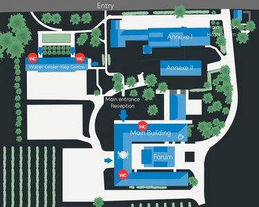 Labeled site map showing the layout of a complex, including buildings such as the Main Building, Forum, and various amenities, with pathways and green spaces indicated.
Map overview of the arrangement of a complex, including buildings like the Main Building, Forum, and various amenities, with pathways and green areas.