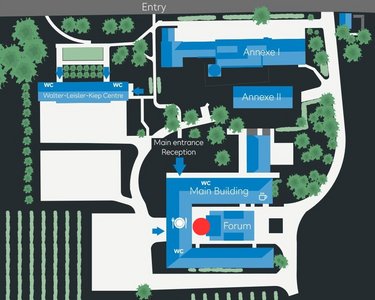 Site plan of an area featuring various buildings, including the main building, the forum, and the reception area. Surrounded by green spaces, trees, and vineyards, with access from Rheingastraße and B42.