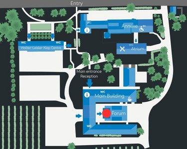 Site plan of an area featuring various buildings, including the main building, reception, and forum, surrounded by green spaces and vineyards. Entrances are clearly marked, and the arrangement of the buildings is presented schematically.