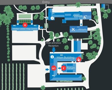 Site plan of an area with various buildings, including the main building, a forum, and a reception area. Markings indicate entrances and key points, surrounded by green spaces and vineyards.